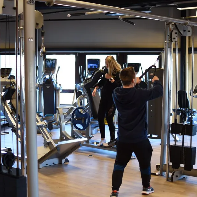Mann står med ryggen til og trener med kabler