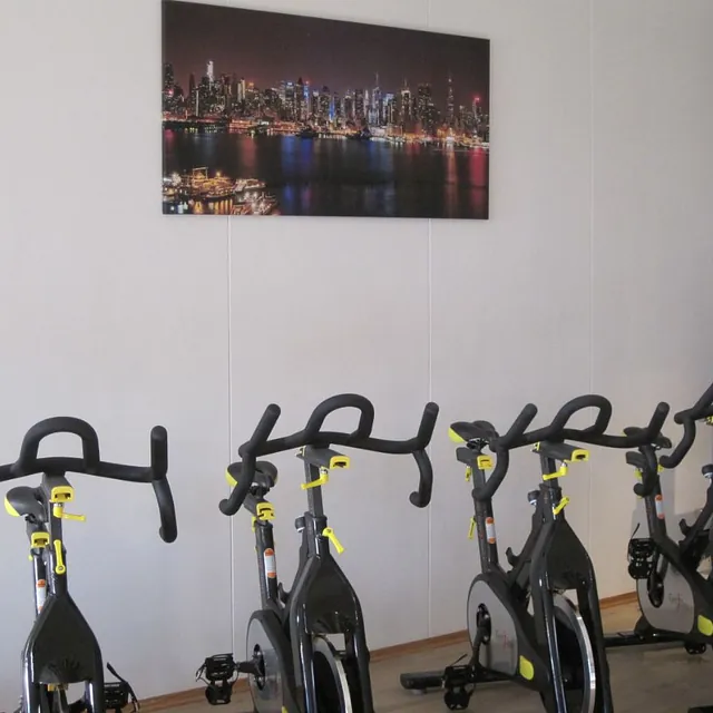 4 spinningsykler med bilde på veggen bak
