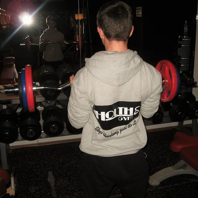 Mann i grå hettegenser trener bicepcurl